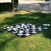 checkers pieces on giant checkers mat outdoors on grass