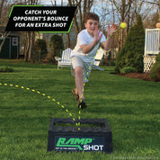 boy catching rampshot ball bouncing off a ramp in a backyard